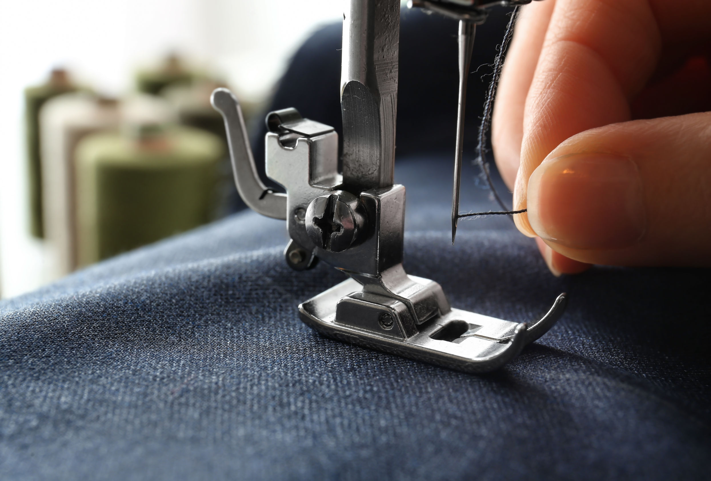 Woman using sewing machine, closeup